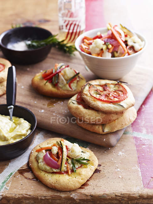 Mini pizza bread topped with giadineira, on chopping board — Stock Photo