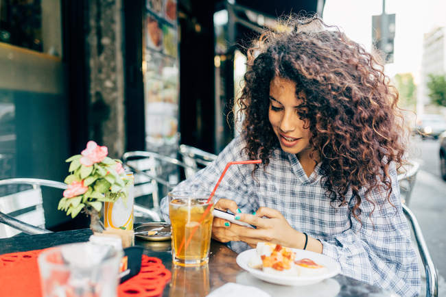 Mulher usando telefone celular no café do pavimento, Milão, Itália — Fotografia de Stock
