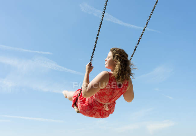 Mujer vestida balanceándose en la playa, Zoutelande, Zelanda, Países Bajos, Europa - foto de stock