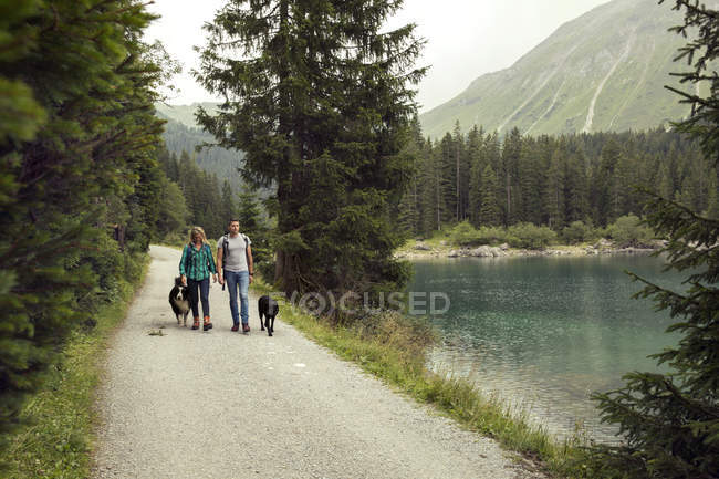 Couple with dogs hiking by lake, Tirol, Steiermark, Austria, Europe — Stock Photo