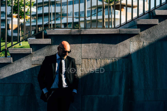 Портрет зрелого бизнесмена, стоящего у ступенек — стоковое фото