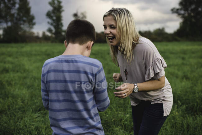 Madre e hijo riendo y disfrutando al aire libre - foto de stock