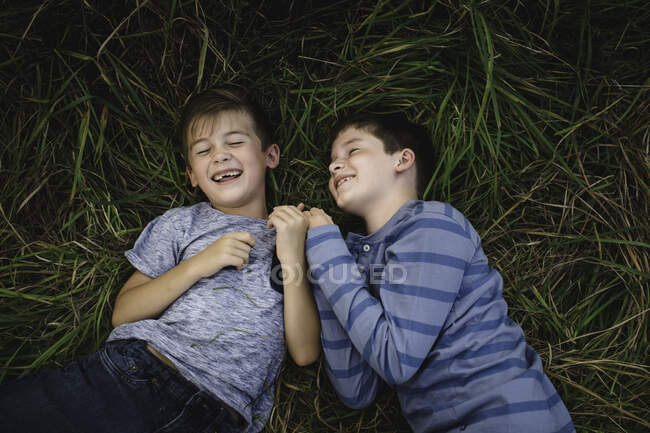 Братья, лежащие на траве — стоковое фото