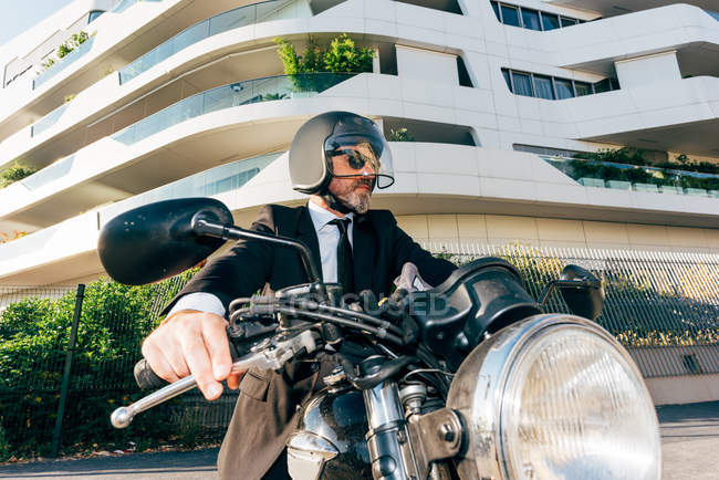 Portrait d'un homme d'affaires mature assis sur une moto — Photo de stock
