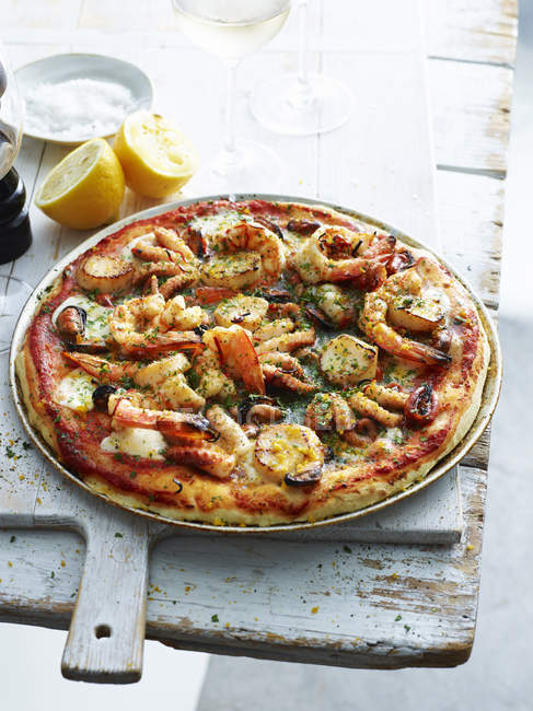 Seafood lovers pizza in pizza dish — Stock Photo