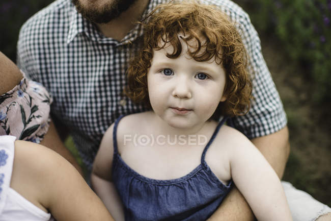 Retrato de menina criança sentada no colo do pai — Fotografia de Stock