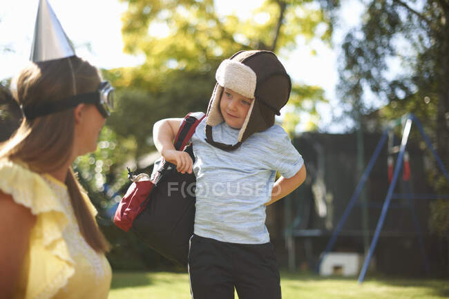 Mature woman with son dressed as pilot in garden — Stock Photo