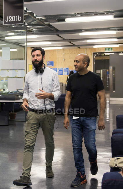 Colleagues walking through office chatting — Stock Photo