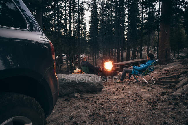Amigos acampando en el bosque junto a la fogata, Mammoth Lake, California, Estados Unidos, América del Norte - foto de stock