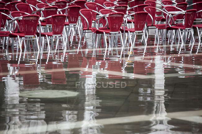 Cafe chairs in flooded St Mark's Square, Venice, Italy — Stock Photo