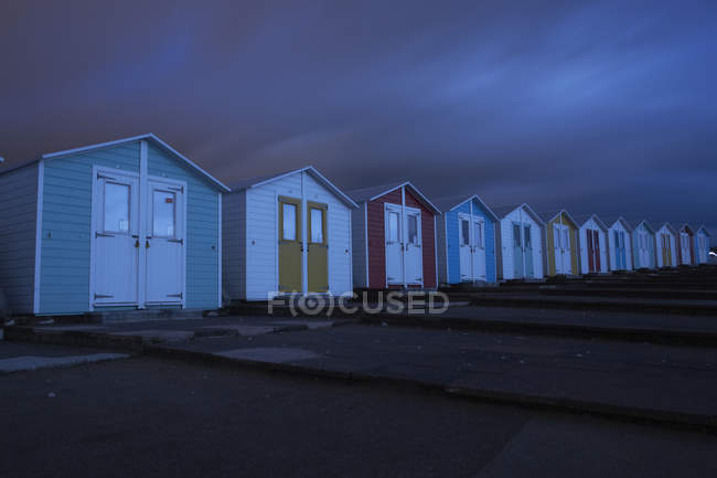 Cabañas de playa por la noche, Bude, Cornwall, Reino Unido, Europa - foto de stock