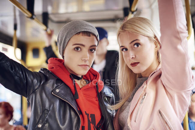 Due giovani donne in piedi sul tram della città — Foto stock