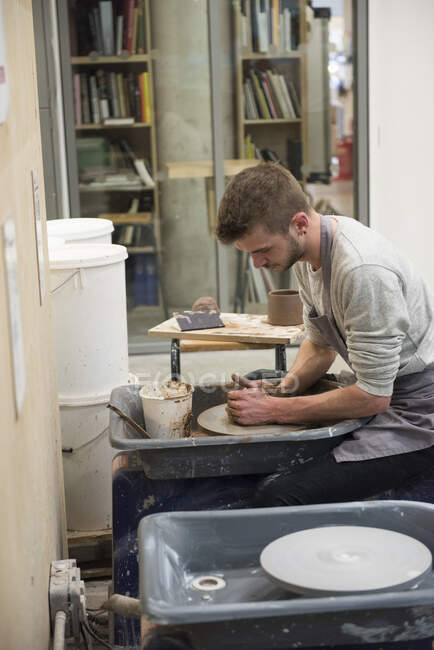 Man in art studio using pottery wheel — Stock Photo