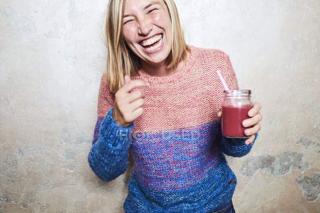 Ritratto di donna che tiene il frullato, ridendo — Foto stock