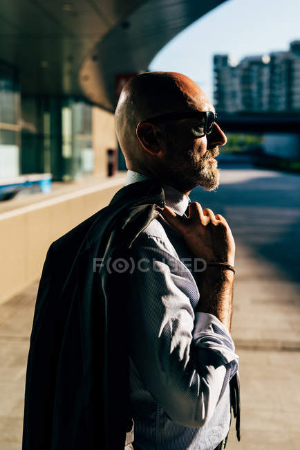 Portrait d'homme d'affaires mature portant une veste de costume au-dessus de l'épaule — Photo de stock