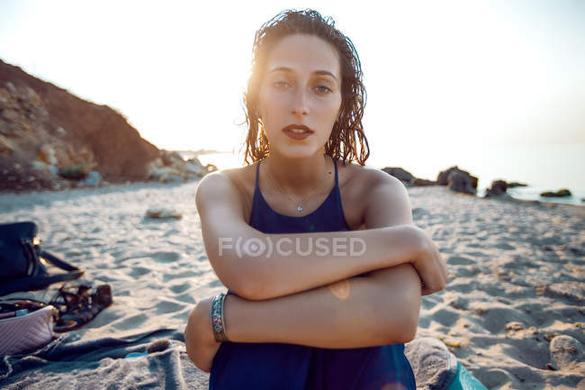 Портрет молодої жінки, що сидить на пляжі — стокове фото