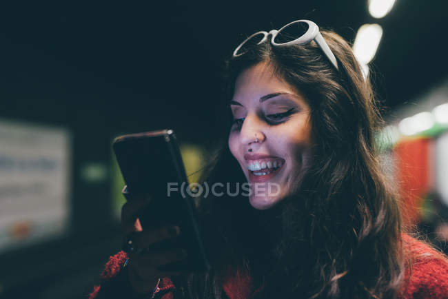 Молодая женщина, на открытом воздухе, ночью, с помощью смартфона, на видео-звонок — стоковое фото