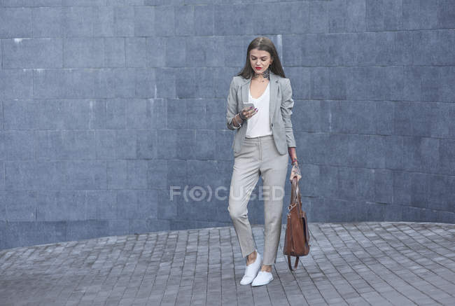 Jeune femme d'affaires utilisant un smartphone en plein air — Photo de stock