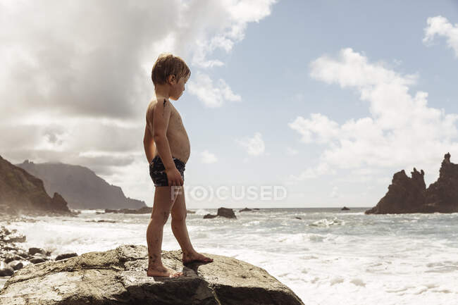 Jeune garçon debout sur le rocher, regardant la vue, Santa Cruz de Tenerife, Îles Canaries, Espagne, Europe — Photo de stock