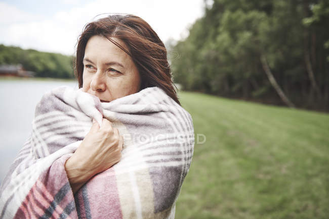 Mature woman wrapped in blanket in rural — Stock Photo