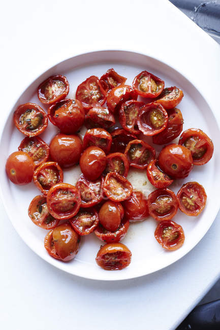 Cherry tomatoes on plate, overhead view — Stock Photo