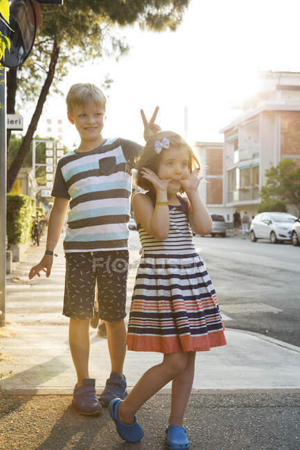 Hermano y hermana en la calle luciendo por la cámara - foto de stock