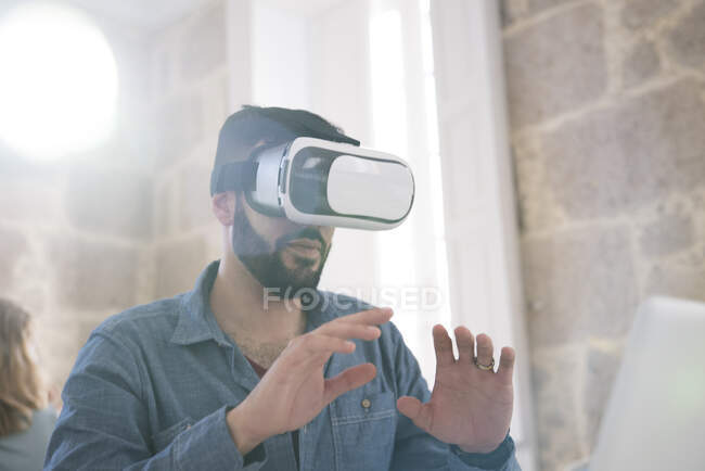 Homme d'affaires portant un casque de réalité virtuelle au bureau — Photo de stock