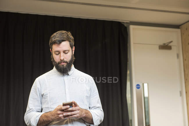 Человек пишет смс на смартфоне — стоковое фото