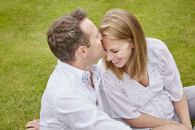 Мужчина целует жену в лоб — стоковое фото
