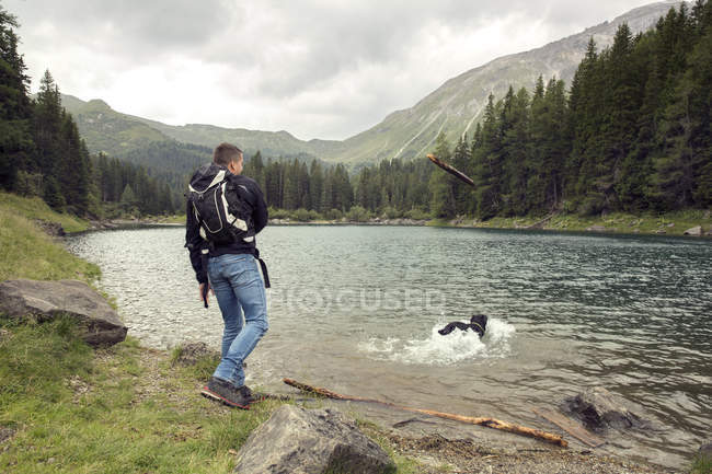 Uomo con cane escursioni in riva al lago, Tirolo, Steiermark, Austria, Europa — Foto stock