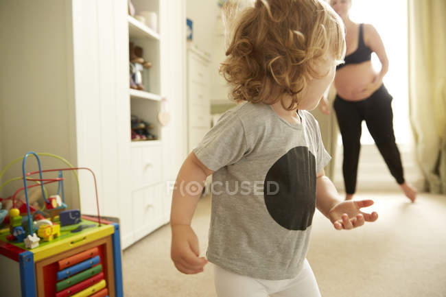 Donna incinta e figlia che giocano in camera da letto — Foto stock