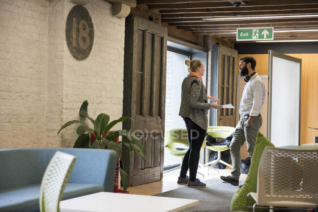 Colleagues in office standing chatting — Stock Photo