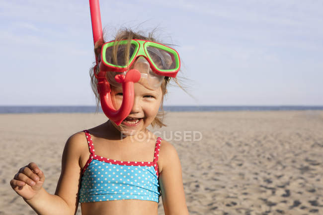 Girl on beach in snorkel smiling at camera — Stock Photo