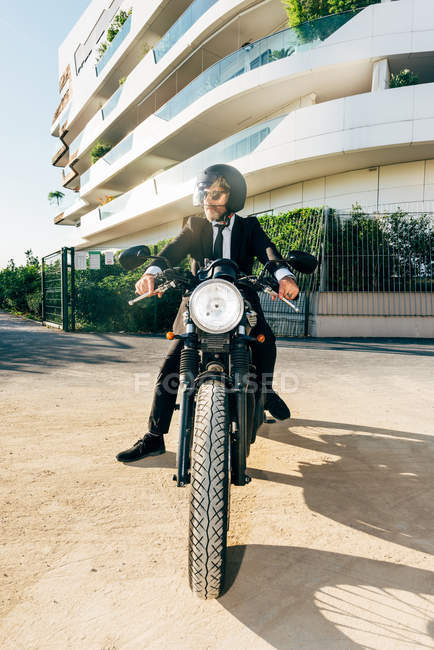 Porträt eines gestandenen Geschäftsmannes auf einem Motorrad — Stockfoto