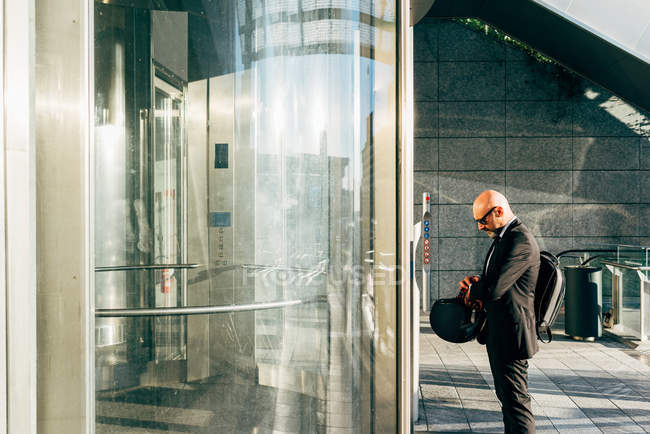 Reifer Geschäftsmann wartet auf Aufzug und schaut auf Armbanduhr — Stockfoto