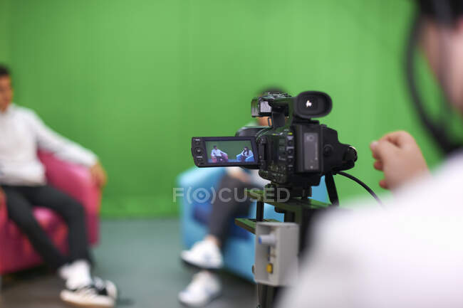 Jóvenes estudiantes universitarios que practican en un estudio de televisión con pantalla verde - foto de stock