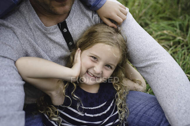 Pai sentado com a filha no campo gramado verde — Fotografia de Stock