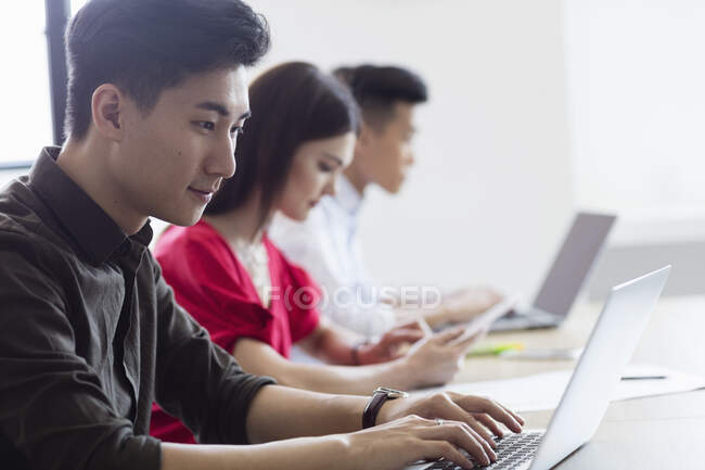 Estudantes sentados e trabalhando lado a lado — Fotografia de Stock