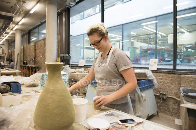Femme en atelier d'artiste faisant de la poterie — Photo de stock
