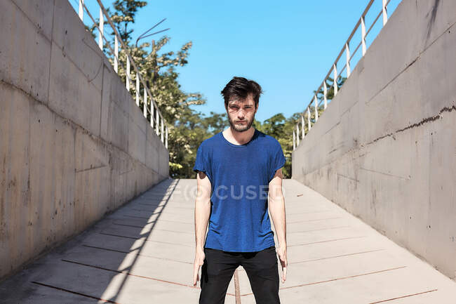 Portrait of young man standing staring from underpass — Stock Photo