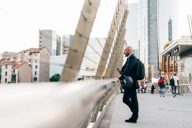Reifer Geschäftsmann steht auf Brücke und blickt auf Aussicht — Stockfoto