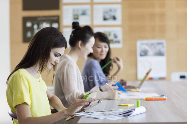 Students sitting and working side by side — Stock Photo