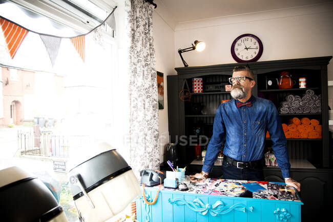 Man at reception desk of quirky hair salon — Stock Photo