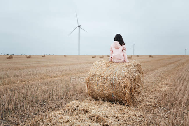 Woman in raincoat sitting on hay bale, Odessa, Ukraine — Stock Photo