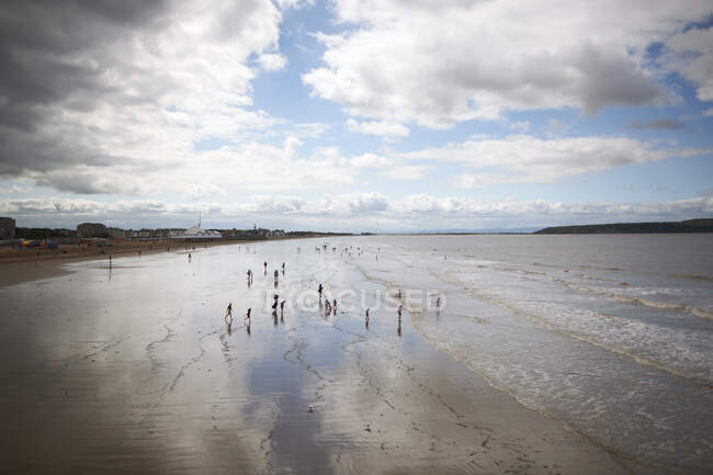 Erhöhter Fernblick auf Menschen am Strand an bewölkten Tagen — Stockfoto