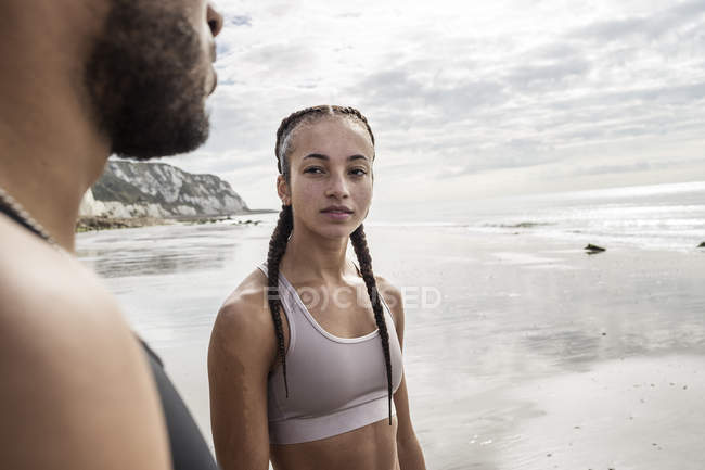 Young male and female looking at each other on beach — Stock Photo
