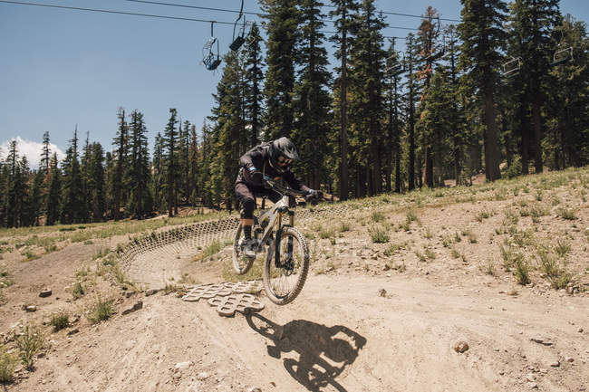 Man cycling on dirt track, jumping bike trick, Mammoth Lakes, California, USA, North America — Stock Photo