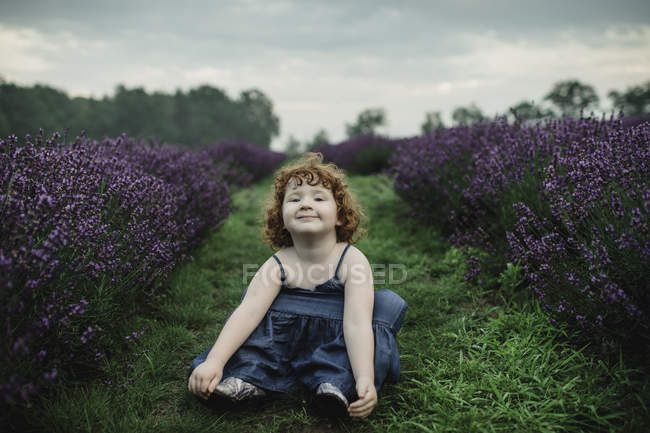 Kleinkind sitzt zwischen Lavendelreihen — Stockfoto