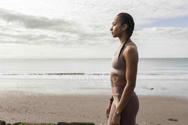 Jeune coureuse regardant de la plage — Photo de stock
