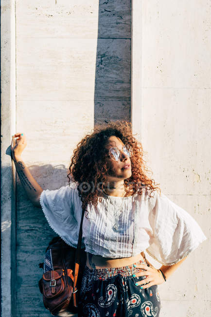 Junge Frau posiert in der Nähe von Steinmauer, Mailand, Italien — Stockfoto